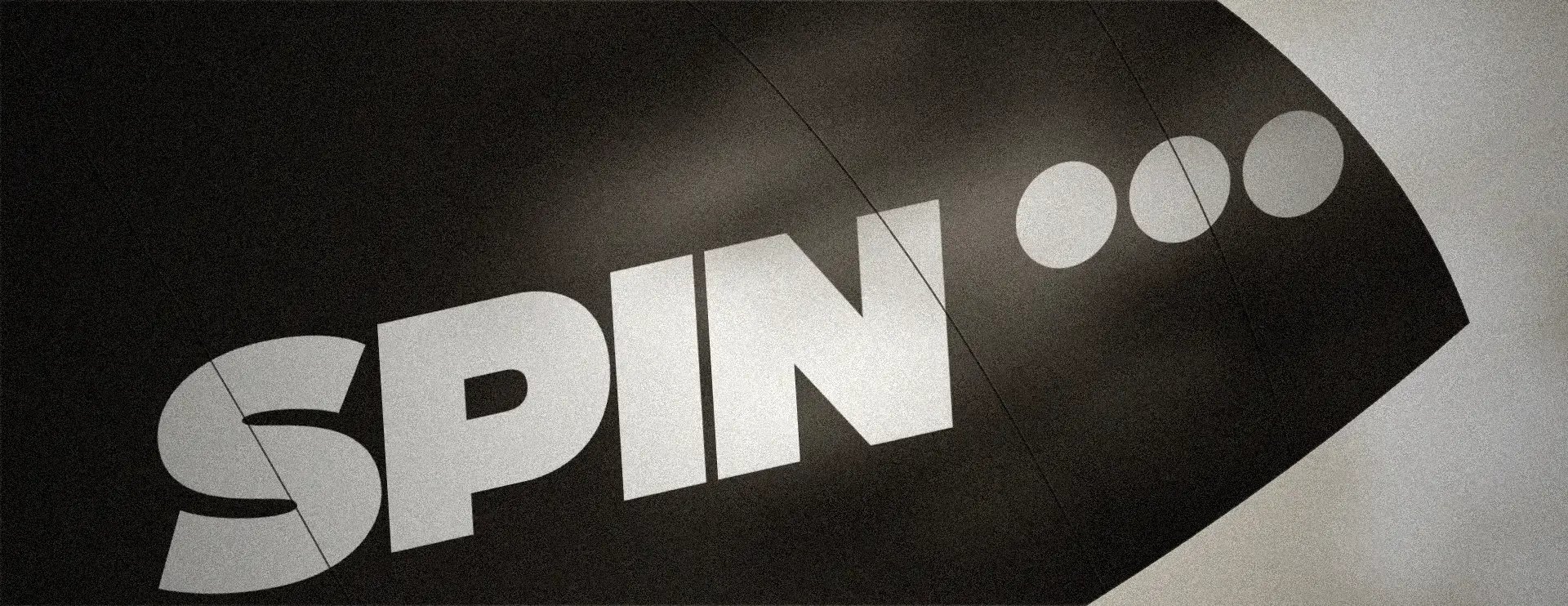 The Spin logo on a curved dark surface